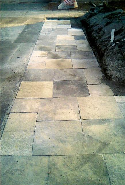 A finished limestone flagstone path laid in a random rectangular pattern